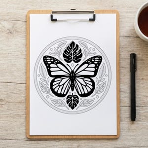 May include: A black and white butterfly illustration on a white paper, clipped to a wooden clipboard. The butterfly is surrounded by leaves and a circular border. A black pen and a white mug are on the wooden surface.