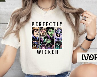 May include: Ivory-colored t-shirt featuring a graphic of four cartoon villains with the text "PERFECTLY WICKED". The graphic includes images of the Evil Queen, Maleficent, Cruella de Vil, and Ursula. The shirt is a light, neutral color.