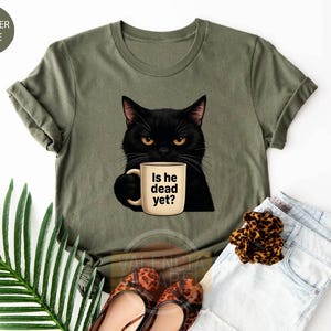 a t - shirt with a black cat holding a cup of coffee