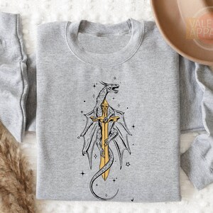 a gray shirt with a yellow dragon on it