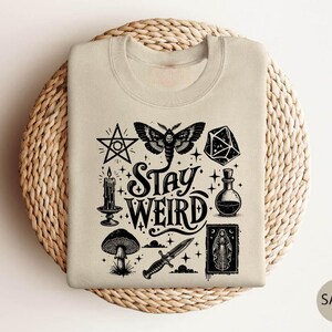 a t - shirt with the words stay weird printed on it