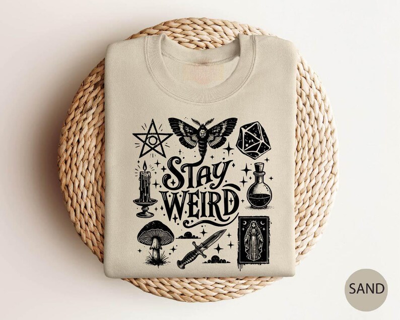 a t - shirt with the words stay weird printed on it