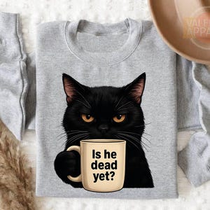 a black cat holding a coffee mug with the words is he dead yet?