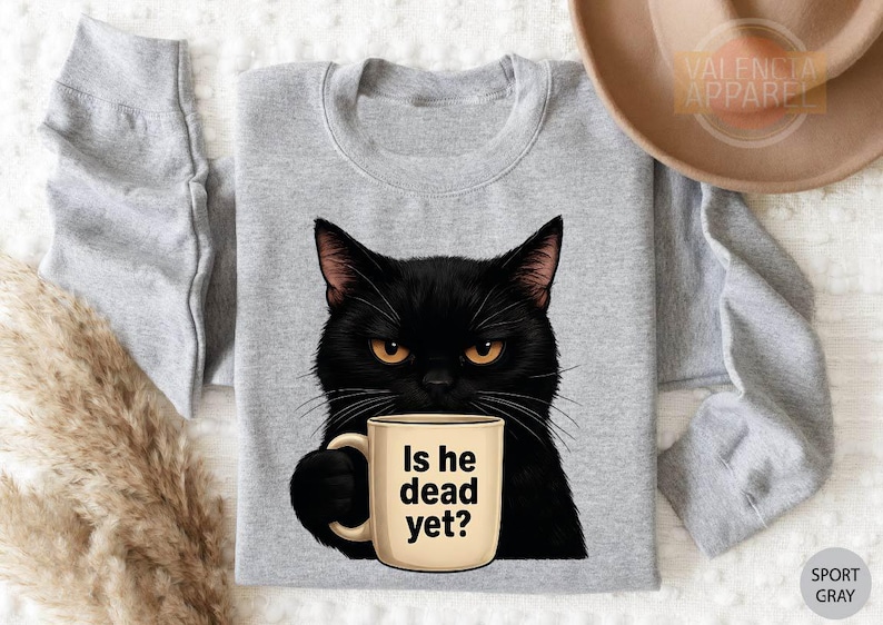 a black cat holding a coffee mug with the words is he dead yet?