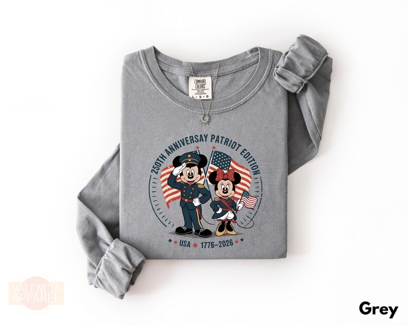 A gray long-sleeved t-shirt with a graphic design featuring two cartoon characters, Minnie Mouse and Mickey Mouse, holding American flags and standing in front of a clock.