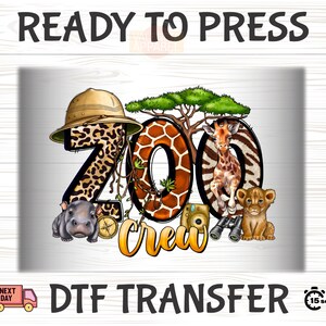 May include: A digital transfer design featuring a cartoon illustration of a zoo crew. The design includes a giraffe, a lion cub, a hippo, a camera, binoculars, and a jungle scene. The text "Zoo Crew" is written in a whimsical font.