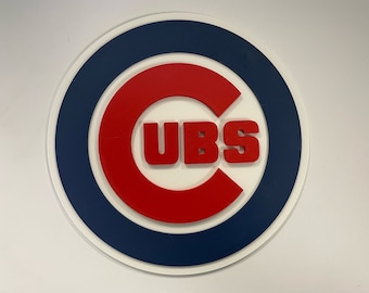 May include: A white, red, and blue circular logo with the word "CUBS" in white letters inside a red "C" shape.