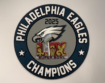 Puede incluir: Una pegatina circular azul y blanca con las palabras "Philadelphia Eagles" y "Champions" alrededor del borde. En el centro hay un águila gris con un casco de fútbol y las palabras "Super Bowl LII" y "2023".