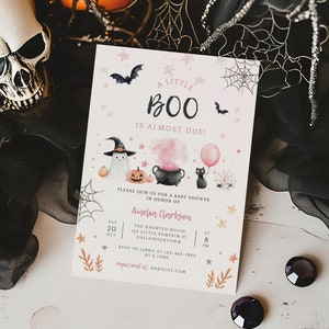 May include: A rectangular baby shower invitation card featuring the text A LITTLE BOO IS ALMOST DUE, with watercolor illustrations of a ghost in a witch hat, a pumpkin, a black cauldron with pink smoke, a black cat with a pink balloon, bats, and webs.