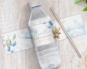 Könnte beinhalten: Eine transparente Wasserflasche mit einem individuellen Etikett für eine Babyparty. Das Etikett zeigt einen Teddybären, Ballons und den Text "Camille's BABY SHOWER MARCH 20, 202X". Ein Holzstrohhalm liegt neben der Flasche.