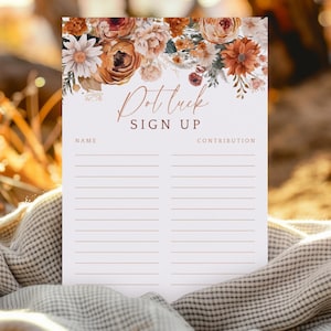 May include: A white paper sign-up sheet with floral accents. The top of the sheet features a watercolor design of orange, brown, and white flowers. The words "Potluck SIGN UP" are written in a brown script font. The sheet has spaces for name and contribution.