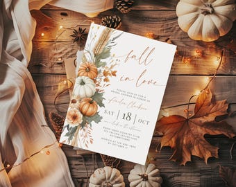 May include: A bridal shower invitation with the words "fall in love" in elegant script. The invitation features watercolor pumpkins, fall foliage, and the date "SAT 18 OCT". The design is set against a rustic wooden background.
