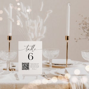 May include: White table number card with black calligraphy that reads "table 6". A black and white QR code is below the number with the text "Please share your photos with us. Simply scan the QR code and upload. Thank you!"
