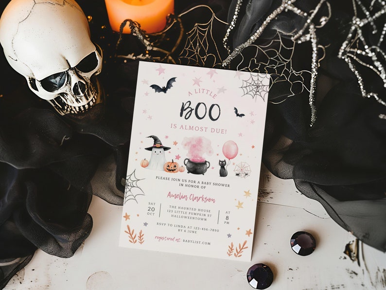 May include: A rectangular baby shower invitation card featuring the text A LITTLE BOO IS ALMOST DUE, with watercolor illustrations of a ghost in a witch hat, a pumpkin, a black cauldron with pink smoke, a black cat with a pink balloon, bats, and webs.