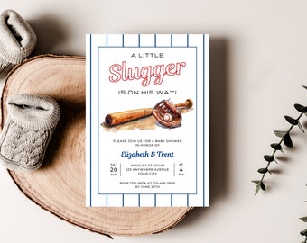 May include: A blue and white baseball-themed baby shower invitation with the text "A Little Slugger Is On His Way!"  The invitation features a watercolor illustration of a baseball bat and glove. The text also includes the date, time, and location of the event.
