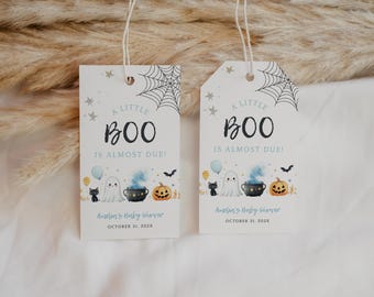 May include: Two rectangular white gift tags with string, featuring a black spiderweb, stars, and the text A LITTLE BOO IS ALMOST DUE. Below, illustrations of a ghost, black cat, cauldron with blue smoke, pumpkin, and balloons, plus custom text.