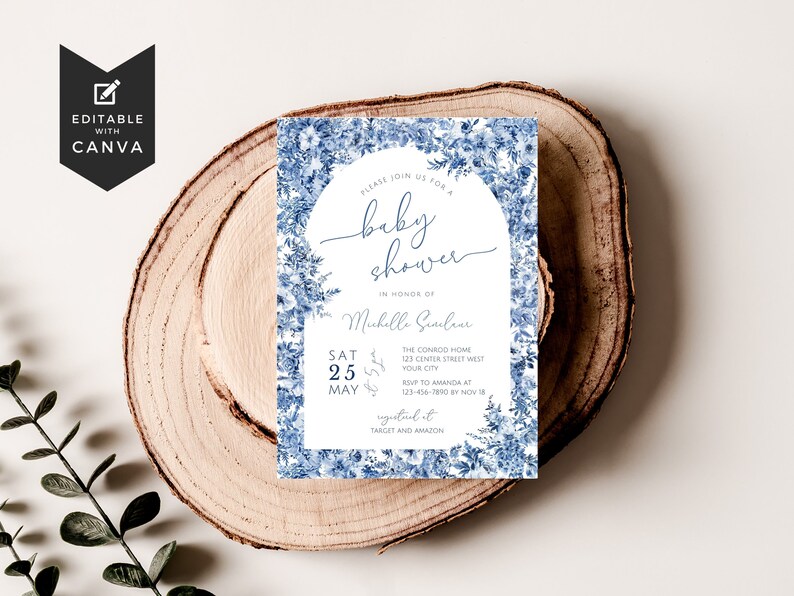 May include: Blue and white floral baby shower invitation with the text "Please join us for a baby shower in honor of Michelle Giuleur. Sat 25 May. The Conrad Home 123 Center Street West Your City. RSVP to Amanda at 123-456-7890 by Nov 18. Registered at Target and Amazon."