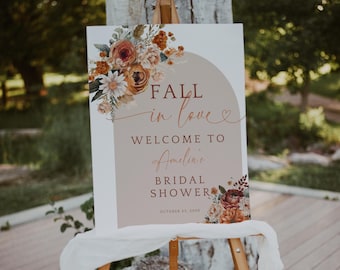 May include: A fall-themed bridal shower welcome sign with a floral design in shades of orange, brown, and white. The sign reads "Fall in love" and "Welcome to Amelia's Bridal Shower, October 23, 2023".
