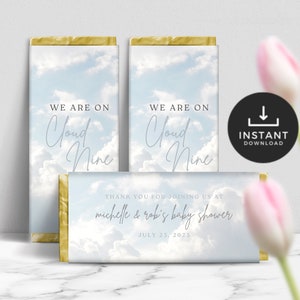 May include: Chocolate bar wrappers with a sky and cloud design. The wrappers have the text "WE ARE ON Cloud Nine" and "THANK YOU FOR JOINING US AT michelle & robi's baby shower JULY 25, 2023". A black circle with "INSTANT DOWNLOAD" is also visible.