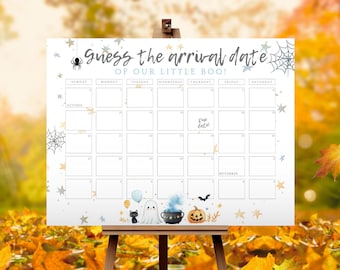 以下が含まれることがあります： Guess the arrival date OF OUR LITTLE BOO!という文字が書かれた白いカレンダーボード。10月と11月の日付枠があり、クモ、クモの巣、星、お化け、黒猫、大釜、ジャック・オー・ランタンのイラストが描かれています。