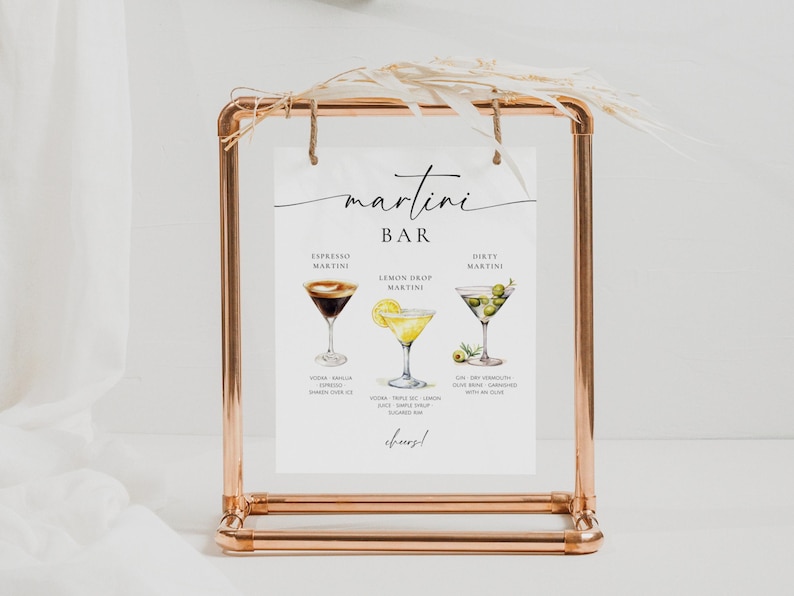 May include: A white sign with black text that reads "martini bar" and features illustrations of three different martini cocktails: espresso martini, lemon drop martini, and dirty martini. The sign is displayed on a copper stand.