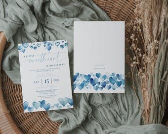 May include: A baby shower invitation with a blue watercolor heart design. The invitation reads "A little sweetheart is on his way" and includes the date and time of the event. The invitation is on a white background with a blue watercolor border.