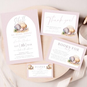 May include: A set of baby shower stationery in soft pink featuring watercolor seashell illustrations. The collection includes an invitation with an arched frame, a thank you card, a books for baby card, and a diaper raffle card, all with elegant typography.