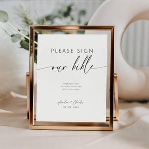 May include: A gold-framed sign with the text "PLEASE SIGN our bible". The sign includes space to highlight a favorite verse and write a note. The sign is personalized with names and a date.