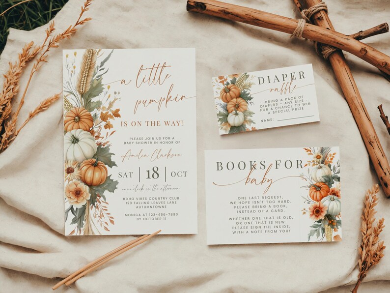 May include: A baby shower invitation set featuring a large invitation, a diaper raffle card, and a books for baby card. The stationery has a cream background with watercolor illustrations of pumpkins, wheat, and autumn leaves in orange and green.