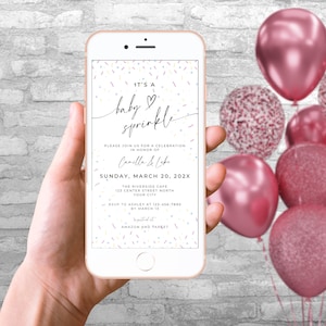 May include: A digital invitation on a smartphone screen for a baby sprinkle. The invitation is decorated with colorful sprinkles and the text "It's a baby sprinkle" in black cursive. The invitation includes the name "Camilla & Luke", the date "Sunday, March 20, 202X", and the location "The Riverside Cafe".