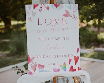 Könnte beinhalten: Ein weißes Schild mit rosa Aquarellherzen und dem Text "LOVE is in the air" und "WELCOME TO Amelia's BRIDAL SHOWER Sat | 15 | Feb"