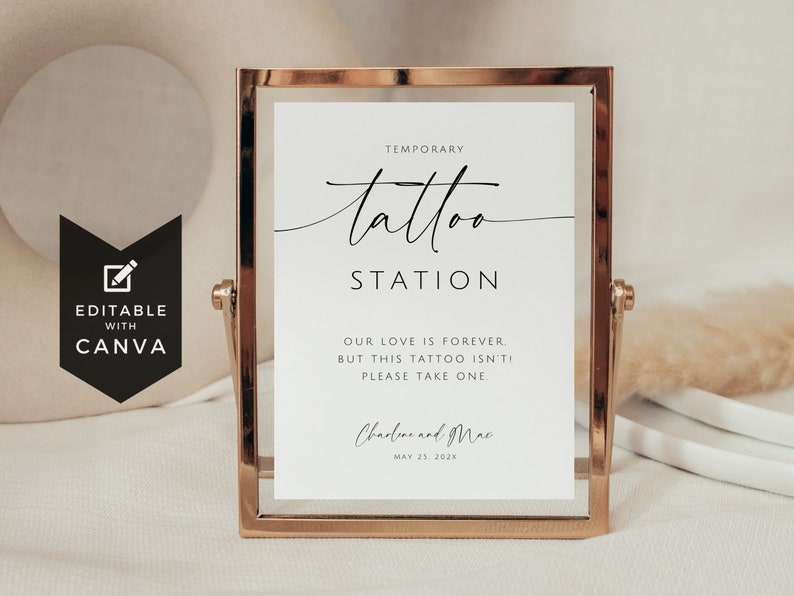 May include: A gold-coloured framed sign with the words "Temporary Tattoo Station" in elegant script. The sign includes the text "Our love is forever, but this tattoo isn't! Please take one." and the names "Charline and Mac" with a date.