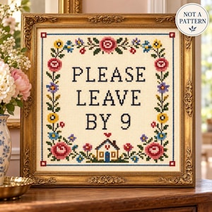 以下が含まれることがあります： クリーム色の布地にPLEASE LEAVE BY 9という濃い青色の文字が刺繍された額入りのクロスステッチサンプラー。赤、黄、青、緑の花のカラフルな縁取りと、下部に小さな家のアイコン、NOT A PATTERNのバッジが付いています。