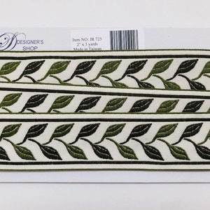 May include: A roll of decorative trim featuring a repeating leaf pattern in shades of green and black on a cream background. The trim is 2 inches wide and 3 yards long. The label reads "DESIGNER'S SHOP".