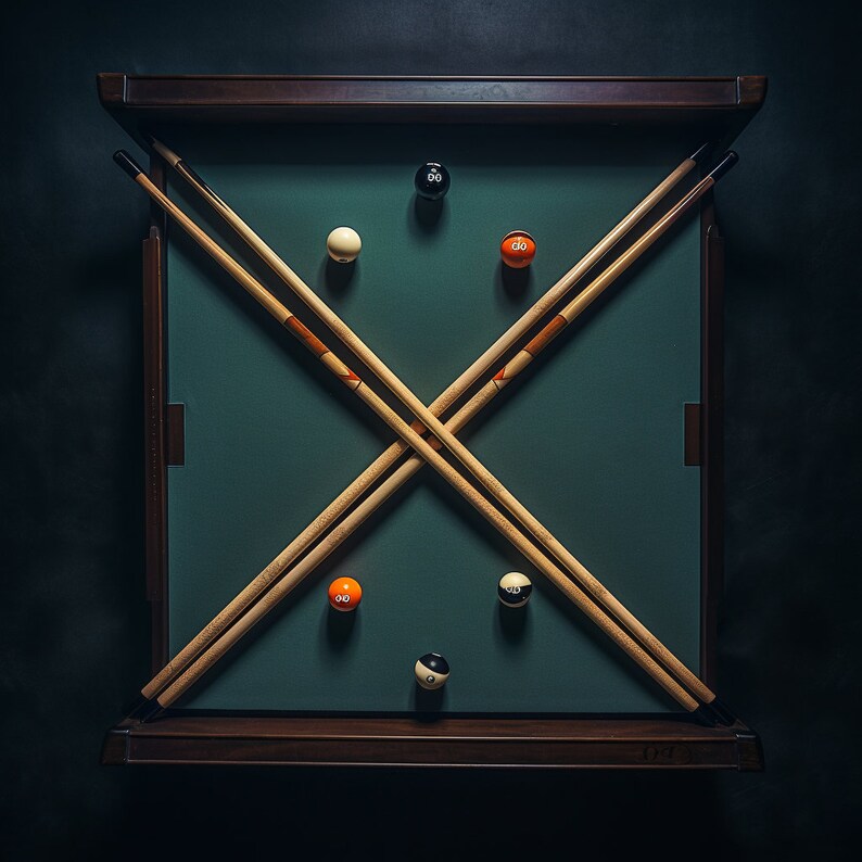 May include: A green felt pool table with two wooden cues crossed in the center. There are six billiard balls on the table, including a white ball, a black ball, and four orange balls.