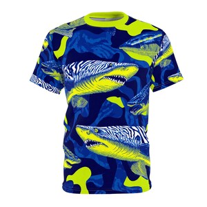 May include: A short-sleeved t-shirt featuring a vibrant shark pattern. The design showcases yellow sharks with zebra-like stripes against a blue camouflage background. The shirt has a neon green collar.