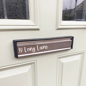 May include: A silver mailbox with a black border and the address "18 Long Lane" printed in white.