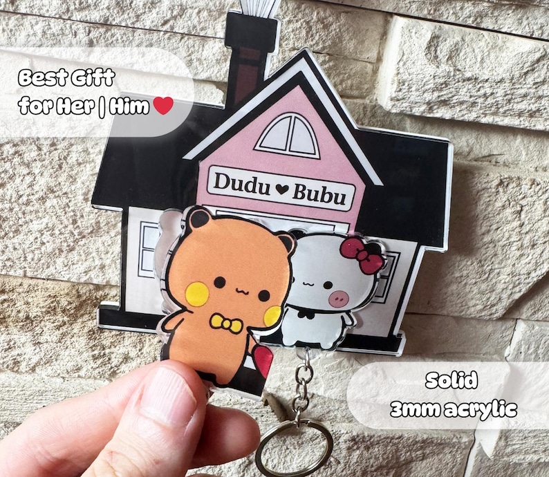 Puede incluir: Un llavero con un dise&ntilde;o de casa con dos personajes de dibujos animados, uno naranja y otro blanco, con el texto "Dudu &hearts; Bubu". El llavero est&aacute; hecho de acr&iacute;lico de 3 mm e incluye el texto "Best Gift for Her | Him".