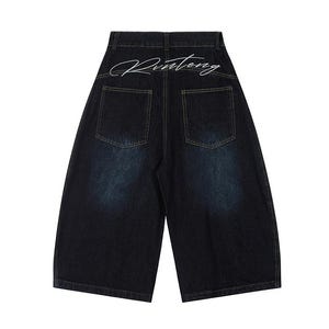 May include: Dark wash denim shorts with a wide leg design. The back features two pockets and the word "Rinteng" in a white script across the waistband. The shorts have a faded, distressed look.
