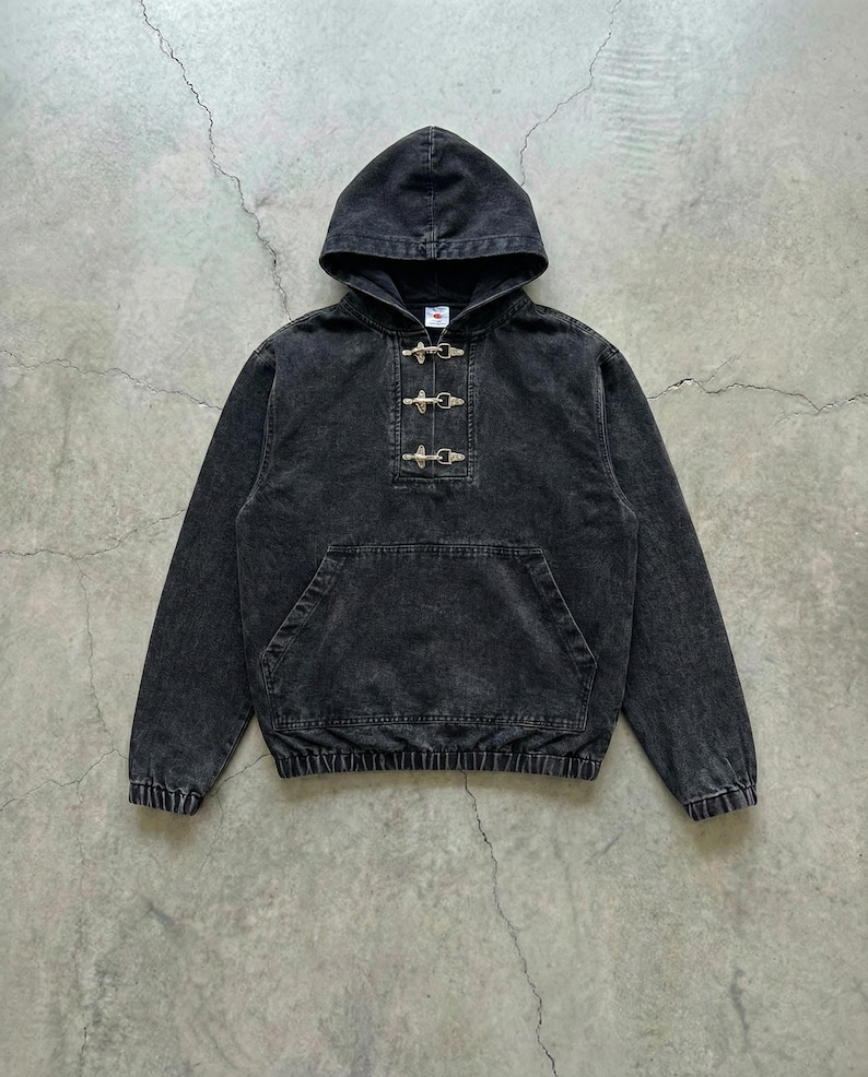 May include: A black hooded sweatshirt with a front pocket and toggle closures. The garment has a washed, faded appearance. The hood is attached, and the cuffs and hem are ribbed. The sweatshirt is made of a soft material.