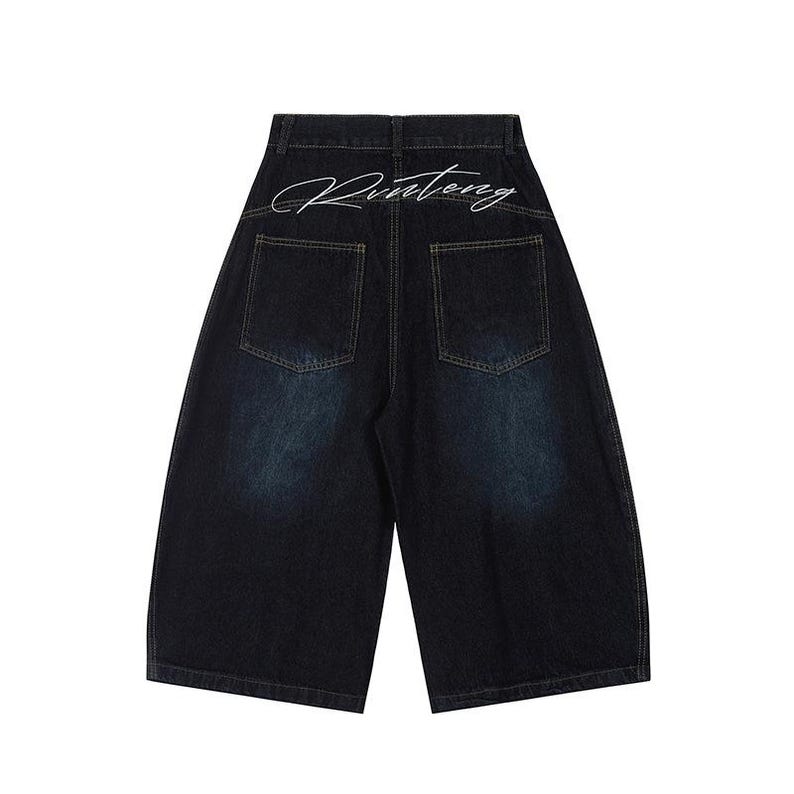 K&ouml;nnte beinhalten: Dunkelblaue Jeansshorts mit weitem Bein. Auf der R&uuml;ckseite befinden sich zwei Taschen und das Wort "Rinteng" in wei&szlig;er Schrift &uuml;ber dem Bund. Die Shorts haben einen verblichenen, abgenutzten Look.