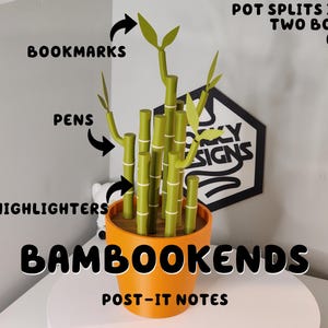 Peut inclure: Un pot orange avec des porte-stylos en forme de bambou vert, intitul&eacute; "BAMBOOKENDS". Le pot se divise en deux serre-livres. Le texte indique que le bambou contient des marque-pages, des stylos, des surligneurs et des post-it. Un panneau noir et blanc est en arri&egrave;re-plan.
