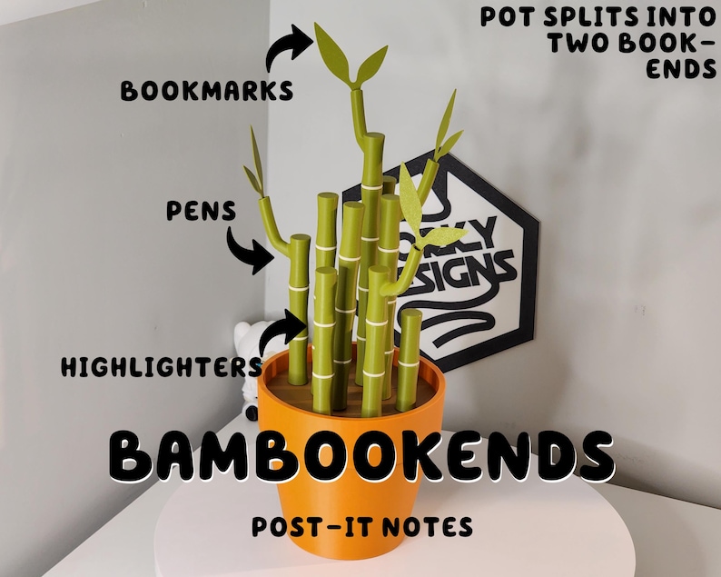 Peut inclure: Un pot orange avec des porte-stylos en forme de bambou vert, intitul&eacute; "BAMBOOKENDS". Le pot se divise en deux serre-livres. Le texte indique que le bambou contient des marque-pages, des stylos, des surligneurs et des post-it. Un panneau noir et blanc est en arri&egrave;re-plan.