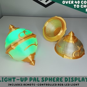 May include: A light-up 3D printed sphere display with a gold finish and a green light inside. The sphere is open and the top half is sitting next to it. The text "LIGHT-UP PAL SPHERE DISPLAY" and "INCLUDES REMOTE-CONTROLLED RGB LED LIGHT" is below the sphere.