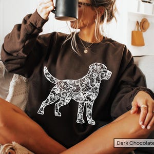 May include: Dark chocolate brown sweatshirt featuring a white lace dog design. The dog silhouette is intricately detailed with a lace pattern. The sweatshirt is a solid color, with the words "Dark Chocolate" in a white rectangle at the bottom.