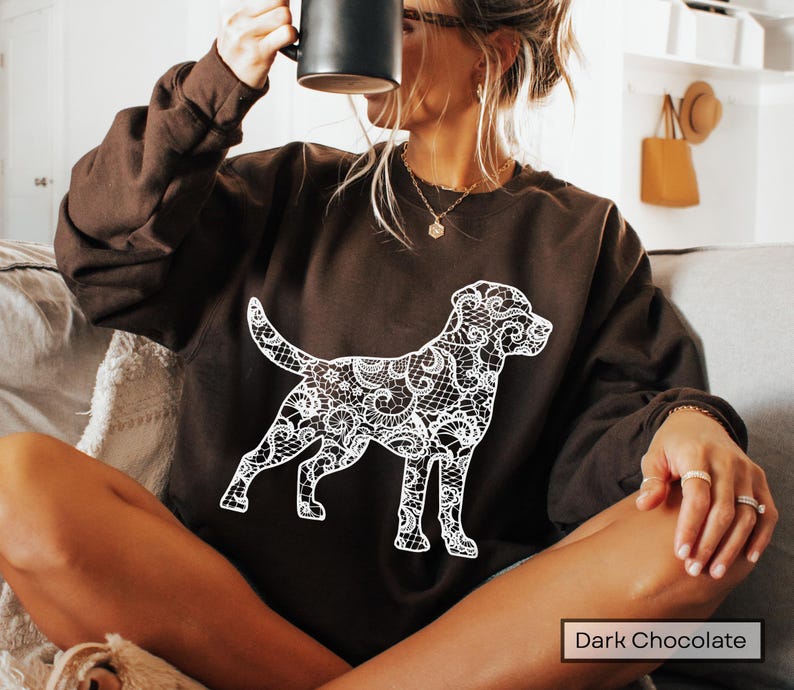 May include: Dark chocolate brown sweatshirt featuring a white lace dog design. The dog silhouette is intricately detailed with a lace pattern. The sweatshirt is a solid color, with the words "Dark Chocolate" in a white rectangle at the bottom.