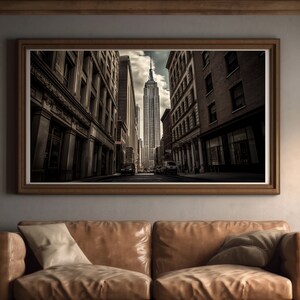 May include: A black and white photograph of a city street with a tall skyscraper in the distance. The street is lined with buildings on both sides, and there are cars driving down the street.