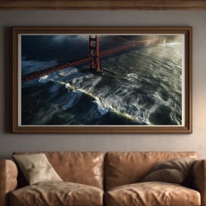 Puede incluir: Una vista aérea del Puente Golden Gate en San Francisco, California. El puente es rojo y cruza un cuerpo de agua con olas agitadas. El cielo está nublado y el sol brilla a través de las nubes.