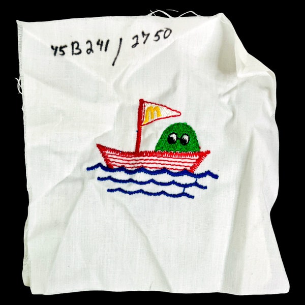 Vintage Embroidered Sample Block of a Nugget or Fry Guy in a Boat | 2.75" x 2"