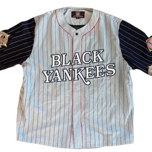 Peut inclure: Maillot de baseball à rayures bleu clair et blanches avec l'inscription "BLACK YANKEES" sur la poitrine. Les manches sont bleu marine avec des rayures blanches et des écussons. Garniture rouge sur le col et les manches.